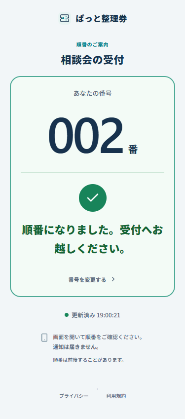 来場者の番号が呼び出され、受付へ来るよう案内するスマートフォン画面